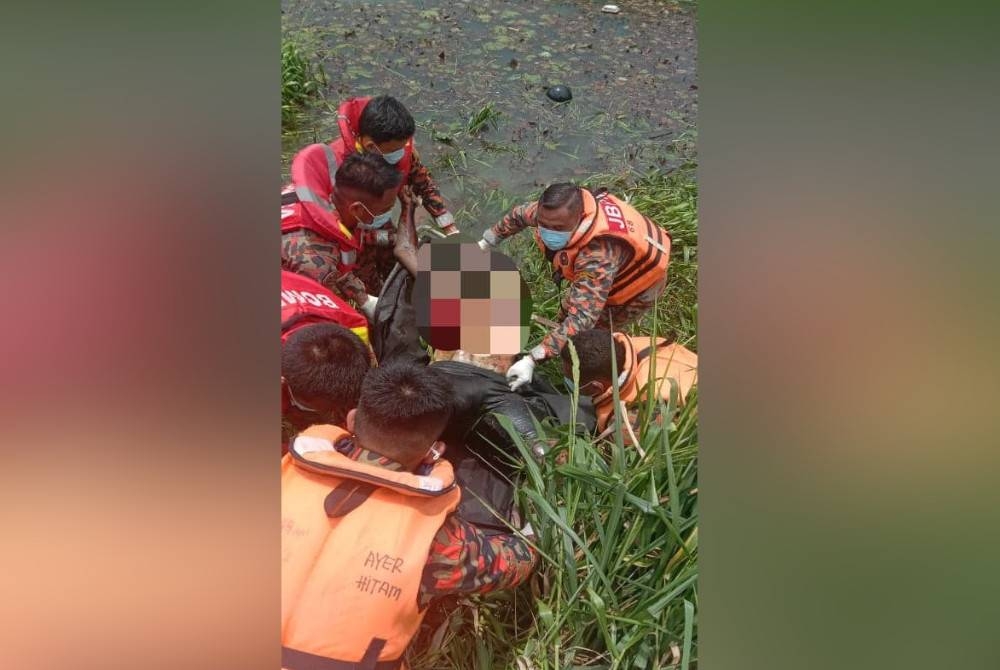 Anggota bomba membantu mengeluarkan mayat mangsa yang ditemui mati di dalam parit di Kampung Parit Lapis Sempadan, Parit Raja pada pagi Ahad. - Foto bomba