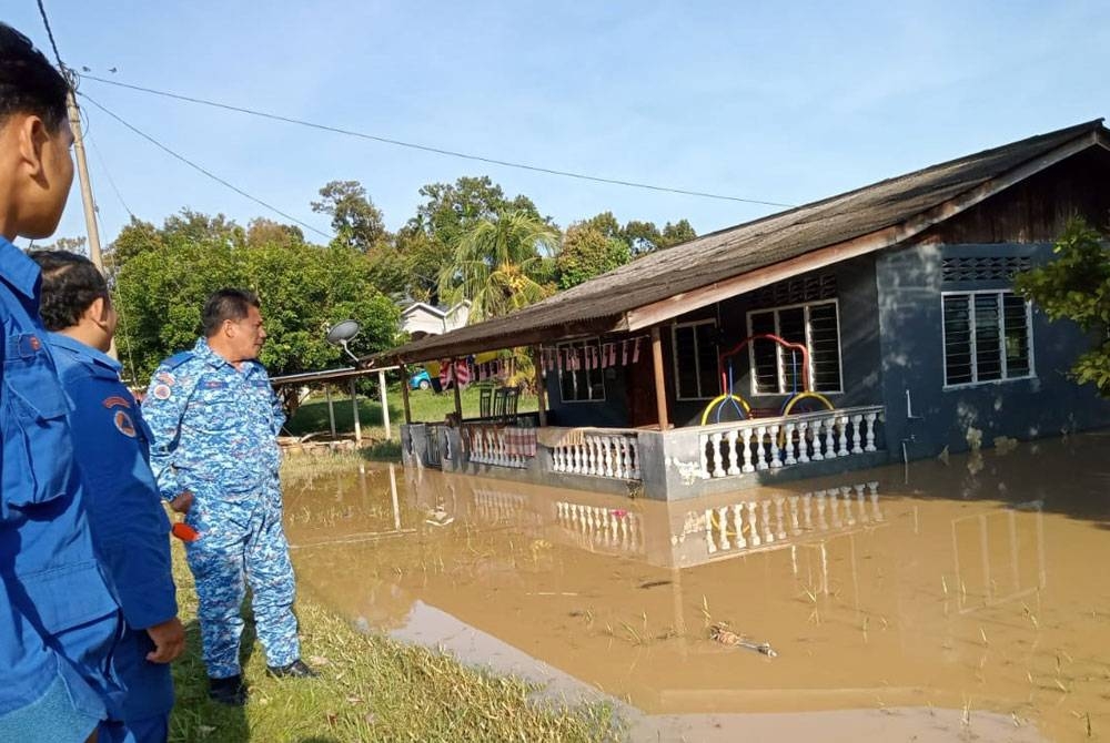 Pasukan APM menjalankan tinjauan di beberapa rumah penduduk yang terjejas banjir di Felda Trolak Selatan pada Isnin. - Foto ihsan APM