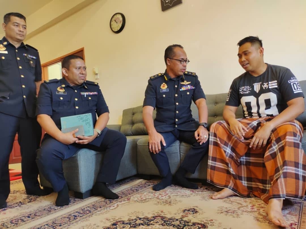 Hanif Yusabra (dua dari kanan) ketika menyantuni Muhammad Nur Hakim (kanan) di Kuaters JPJ Pedas, Rembau pada Isnin. 