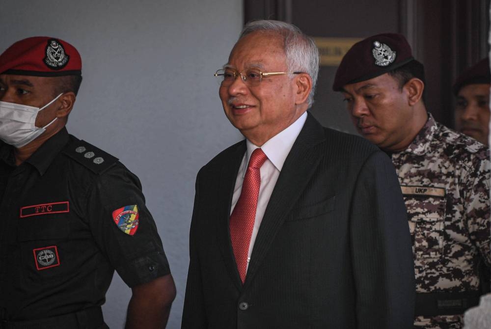 Najib (tengah) hadir ke Mahkamah Tinggi hari ini atas pertuduhan berkaitan dana 1Malaysia Development Berhad (1MDB). - Foto Bernama