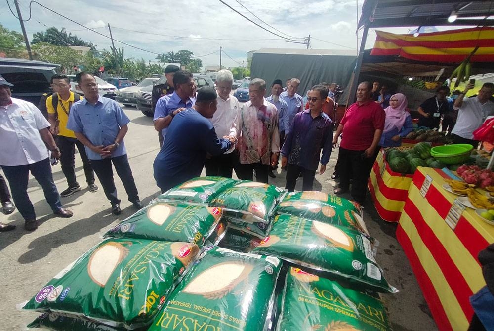 Mohamad (tengah) meninjau bekalan beras putih tempatan di Agrobazaar Kedai Rakyat milik usahawan bimbingan FAMA di Jalan Kebun Tambahan, Seksyen 30 pada Khamis.