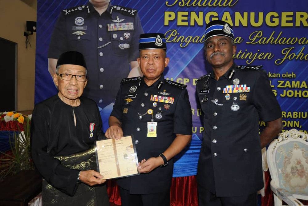 Kamarul Zaman (tengah) menyerahkan sijil penghargaan Istiadat Penganugerahan Pingat Jasa Pahlawan Negara (PJPN) Kontinjen Johor, pada Khamis.