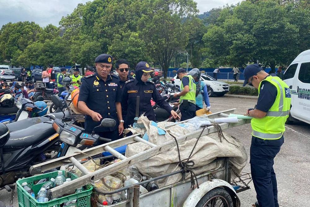 Erick (kiri) melihat motosikal yang disita JPJ dalam Ops Pewa di Jalan Tasek Tambahan, Ampang, Selangor pada Khamis.