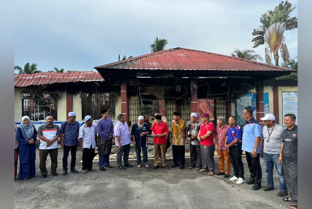 Ahmad Maslan (tengah) menyampaikan sumbangan kepada SMA Bugisiah Tampok Benut yang terlibat dalam kebakaran pada Jumaat.