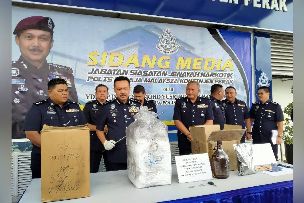 Mohd Yusri (dua dari kiri) menunjukkan dadah yang dirampas di dalam sebuah kereta di tepi Jalan Gopeng, Kampung Gunung Rapat di sini.