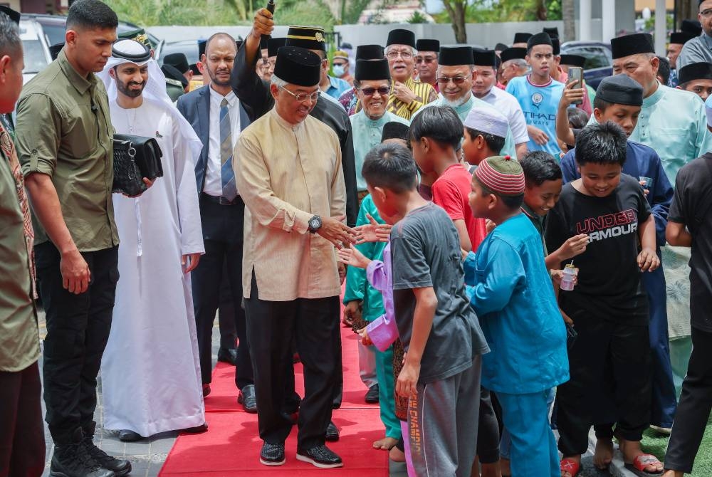 Al-Sultan Abdullah berkenan bersalaman dengan kanak-kanak yang menunggu keberangkatan tiba baginda bagi menunaikan solat jumaat di Masjid Tengku Mahkota Tengku Hassanal Ibrahim Alam Shah,Temerloh hari ini. - Foto Bernama