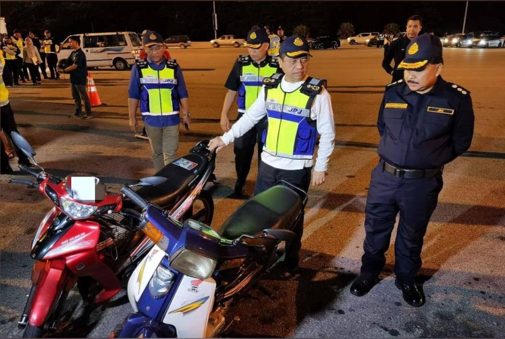 Aedy Fadly (dua kanan) menunjukkan antara motosikal yang diperiksa dalam Op Bersepadu di Plaza Tol Awan Besar pada Jumaat.