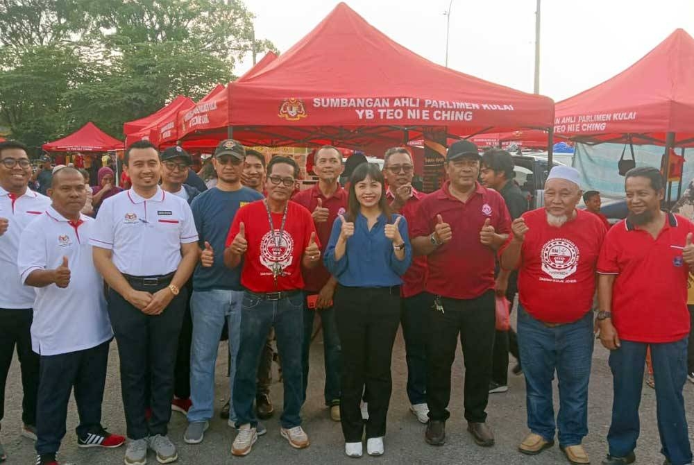 Nie Ching (tengah) bergambar bersama wakil Persatuan Peniaga dan Penjaja Daerah Kulai di Pasar Pagi Merbau, Bandar Putra, Kulai pada Sabtu