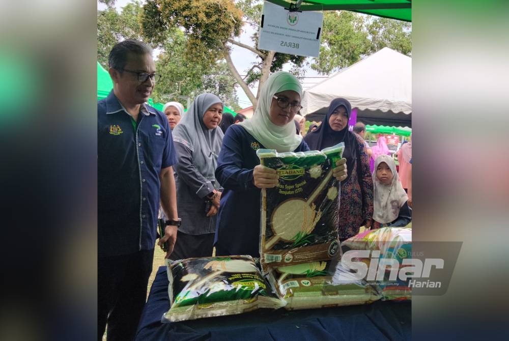 Azulita (tengah) meninjau beras yang dijual selepas merasmikan Jualan Agro Madani@Peladang Outlet anjuran Kementerian Pertanian dan Keterjaminan Makanan.