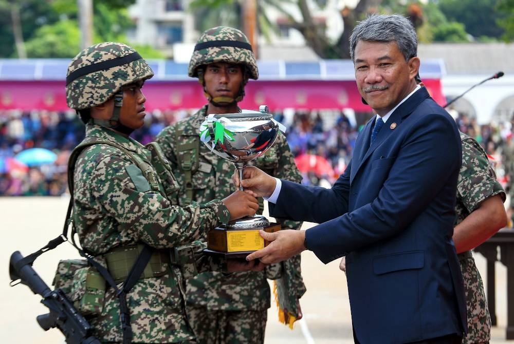 Mohamad (kanan) menyampaikan Anugerah Perajurit Muda Keseluruhan Terbaik kepada perajurit muda, Faddry Izhan Norhan pada acara Perbarisan Tamat Perajurit Muda Lelaki Siri 197/23 dan Wanita Siri 48/23 di Pusat Latihan Asas Tentera Darat (PUSASDA). - Foto Bernama