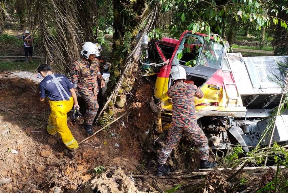 Anggota bomba cuba mengeluarkan mangsa yang tersepit dala kemalangan berkenaan. - foto bomba