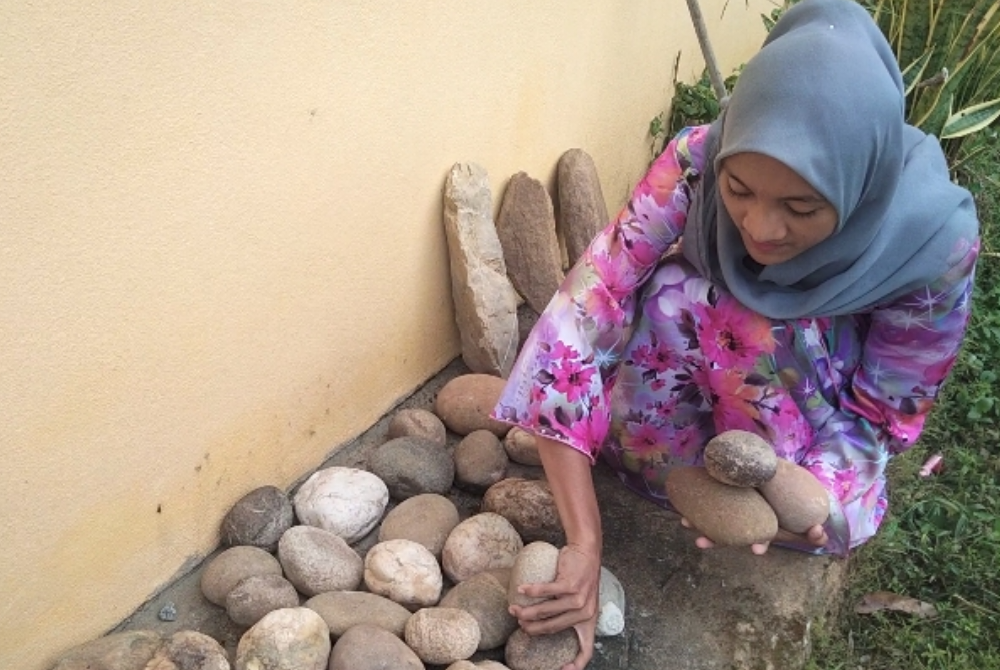 Masmieliya menyusun batu sungai yang diambil di sebuah sungai di Gua Musang.