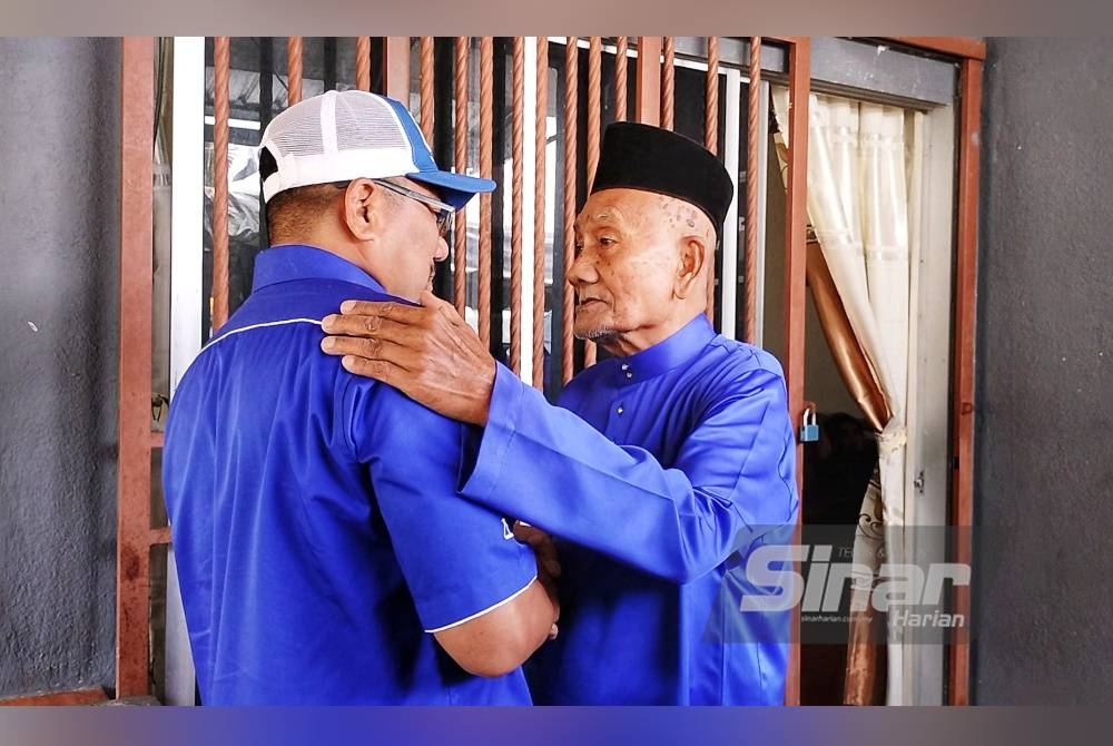 Abu Adam (kanan) memberikan pesanan kepada anaknya, Amizar yang menjadi calon BN di PRK DUN Pelangai.