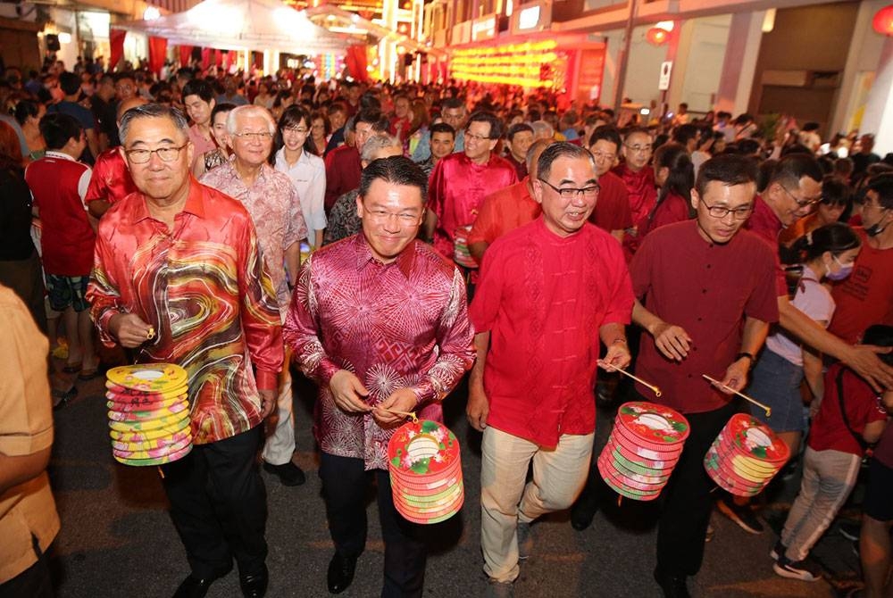 Kor Ming (dua dari kiri) menyertai perarakan tanglung sempena Majlis Perayaan Kuih Bulan Octagon dan Majlis Pembukaan Pesta Makanan Jalanan Paloh di Ipoh pada Sabtu