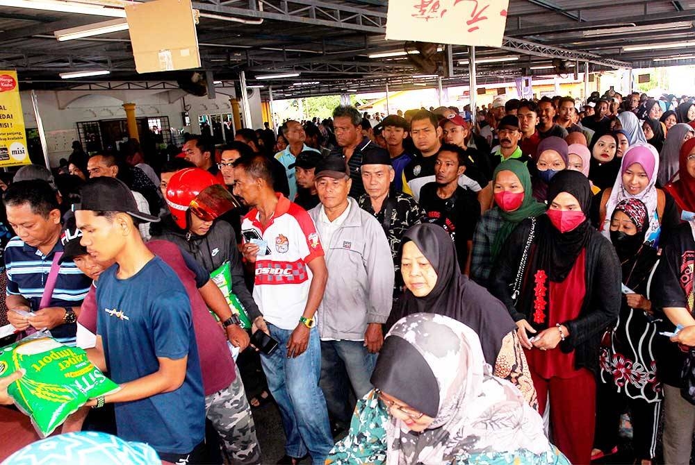 Orang ramai datang seawal 6 pagi untuk membeli beras putih import berjenama SITI dengan hanya RM1 pada Program Misi Jual Beras RM1 di Padang Kampung Dato&#039; Seri Kamaruddin Manjung hari ini. Foto Bernama