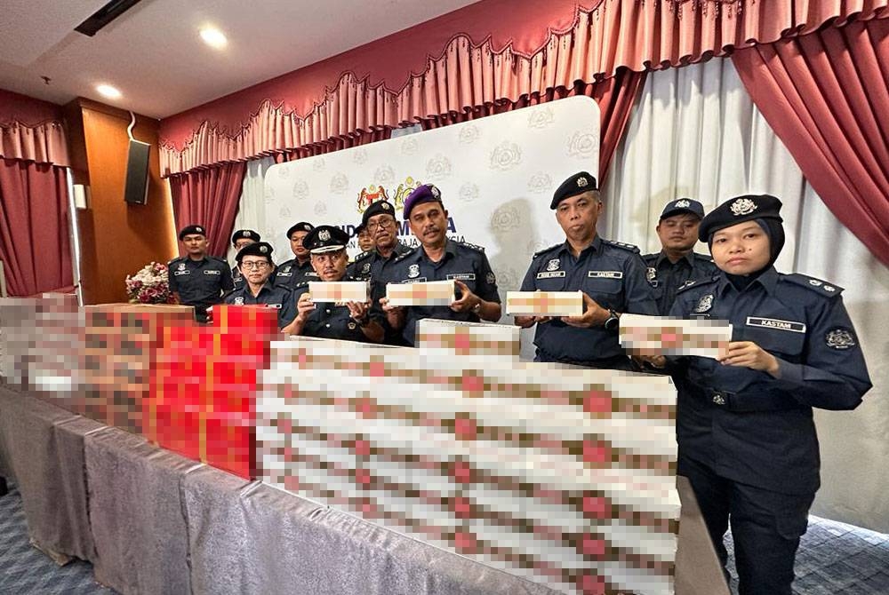 Sazali (empat dari kanan) menunjukkan rokok seludup yang dirampas dan cuba dibawa masuk ke Singapura ketika sidang akhbar di Menara JKDM Johor, Johor Bahru pada Ahad.