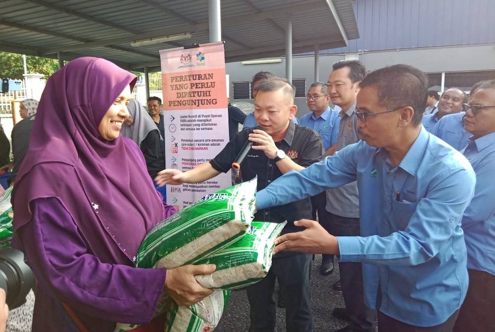 Foong Hin (dua dari kiri) meninjau jualan beras di Pusat Operasi FAMA Senawang pada Selasa.