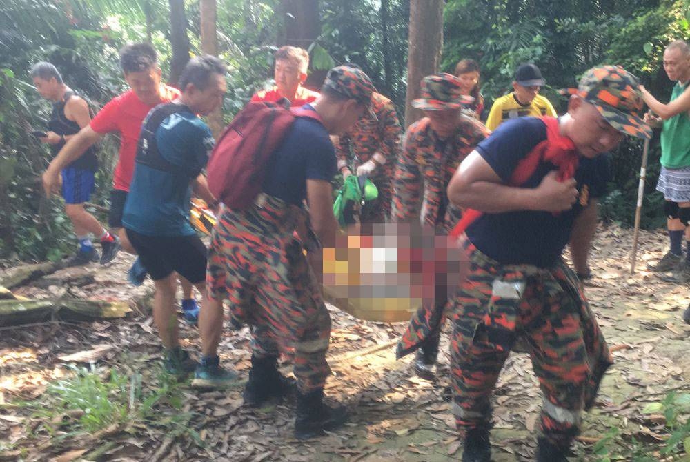 Anggota bomba membawa turun mangsa yang dilaporkan pengsan di Bukit Aspek pada Rabu.