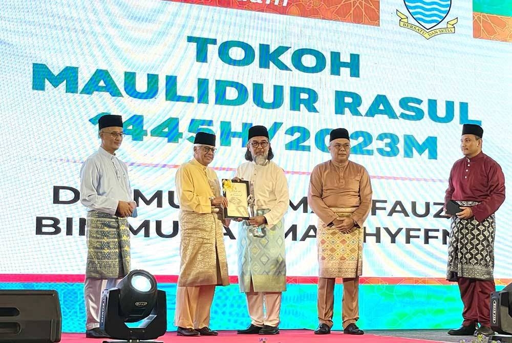 Ahmad Fuzi (dua dari kiri) menyampaikan anugerah Tokoh Maulidur Rasul Pulau Pinang 2023 kepada Muhammad Fauzy pada Khamis.