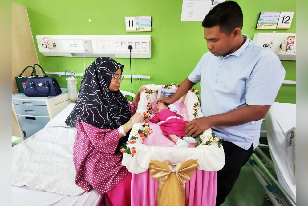 Mimi Azuani bersama suaminya, Mohd Faizul ceria di samping bayi perempuan mereka ketika ditemui sempena program Permata Maulidur Rasul di Pusat Rawatan Ibu dan Bayi (PRIBA) di Kuala Terengganu, pada Khamis.