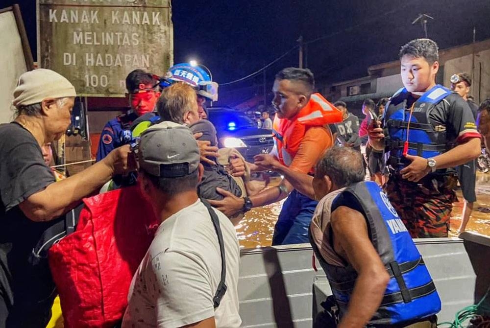 Anggota Angkatan Pertahanan Awam Malaysia (APM) menyelamatkan mangsa yang terperangkap dalam banjir di Kedah.