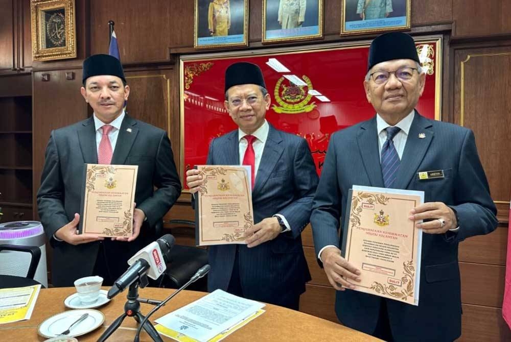 Nazran (tengah), Nik Mohd Shafriman (kiri) dan Mamat Ariffin memegang senarai penerima Pengurniaan Kehormatan negeri Kelantan.