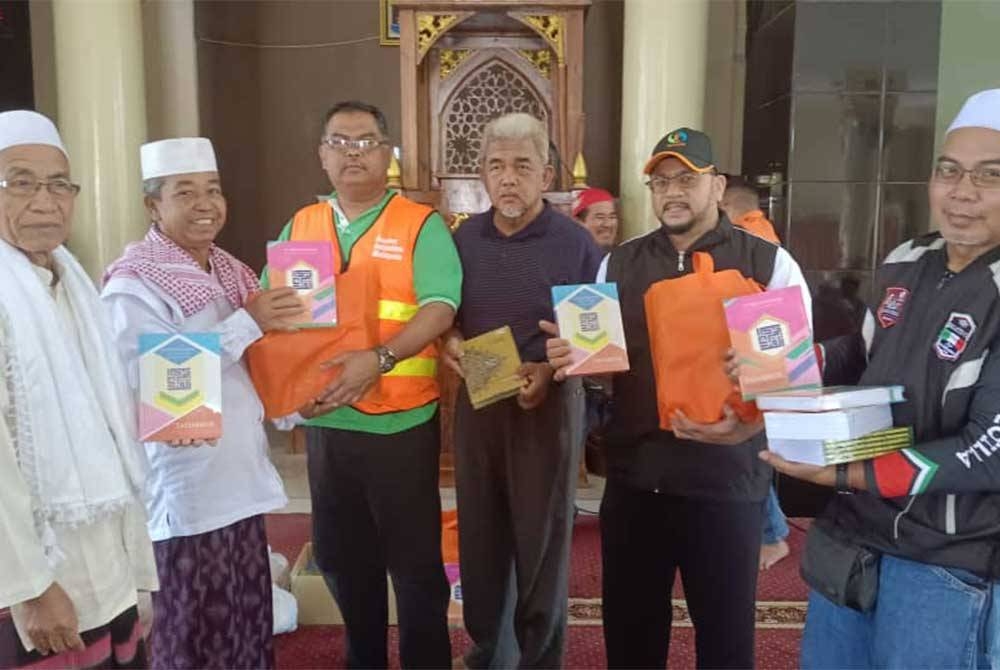 Rozi (dua kanan), Mas Imran (tiga kiri) dan Hashim (tengah) menyerahkan Al-quran dan sumbangan bahan makanan di Masjid Jami&#039;Fathurrahman, Desa Pengadangan, Kecamatan Pringgasela, Lombok Timor, Lombok, Indonesia pada Jumaat.