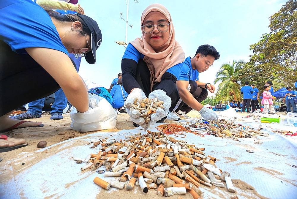 Seorang sukarelawan menunjukkan puntung rokok yang berjaya dikutip kumpulannya.