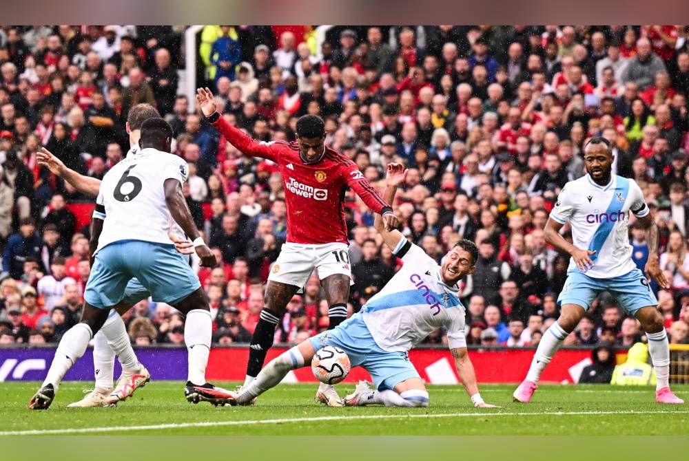 Rashford (tengah) mengawal bola ketika di asak pemain Crystal Palace.- Foto AFP