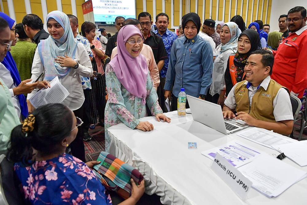 Dr Wan Azizah (tiga dari kiri) yang juga Ahli Parlimen Bandar Tun Razak beramah mesra bersama penerima sumbangan pada program Pembasmian Miskin Tegar bagi Parlimen Bandar Tun Razak di Institut Latihan DBKL pada Ahad. - Foto Bernama