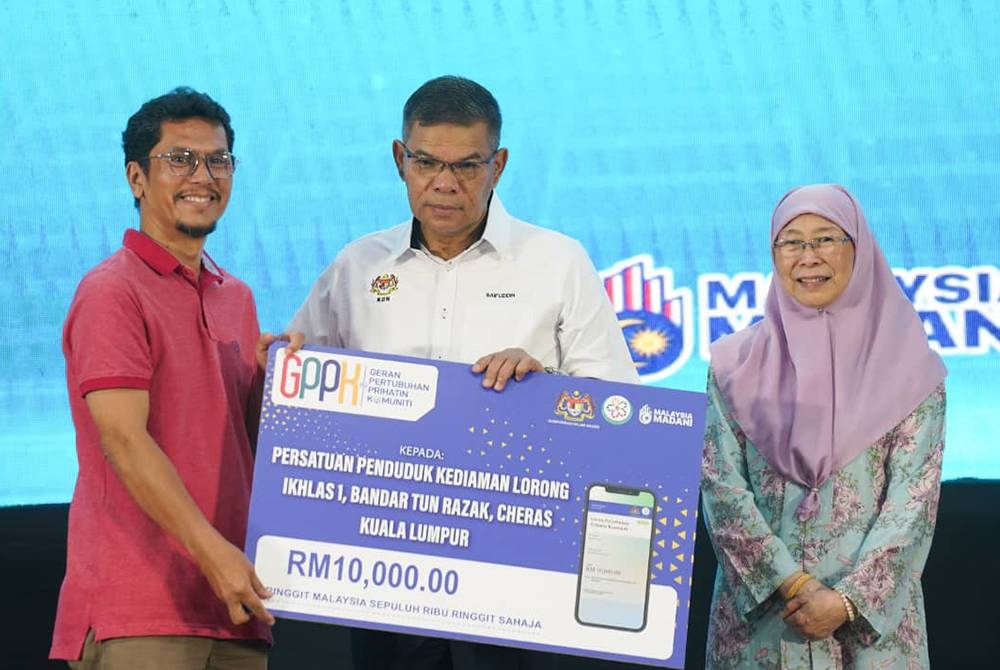 Saifuddin menyerahkan Geran Pertubuhan Prihatin Komuniti (GPPK) kepada wakil persatuan penduduk pada Program KDN Madani di Kompleks Sukan Bandar Tun Razak pada Ahad.