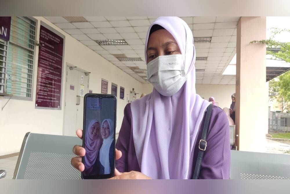 Melati menunjukkan gambar kenangan bersama mangsa pada Aidilfitri lalu semasa ditemui di Jabatan Forensik Hospital Sultanah Bahiyah (HSB), dekat sini pada Ahad.