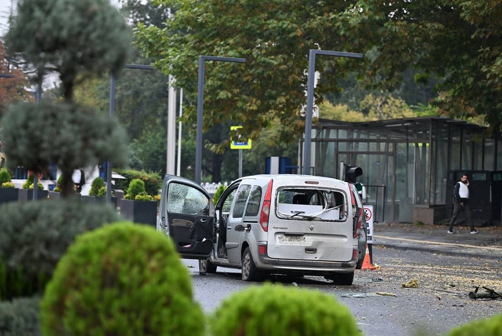 Sebuah kenderaan dipercayai dinaiki dua penyerang kelihatan tersadai di sebatang jalan berhampiran ibu pejabat polis Turkiye di Ankara pada Ahad. - Agensi