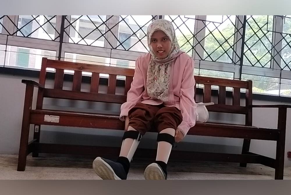 Arisha Maisara menunjukkan kedua-dua belah kalinya yang memakai alat sokongan untuk berdiri ketika mendaftar masuk ke UTM pada Ahad.