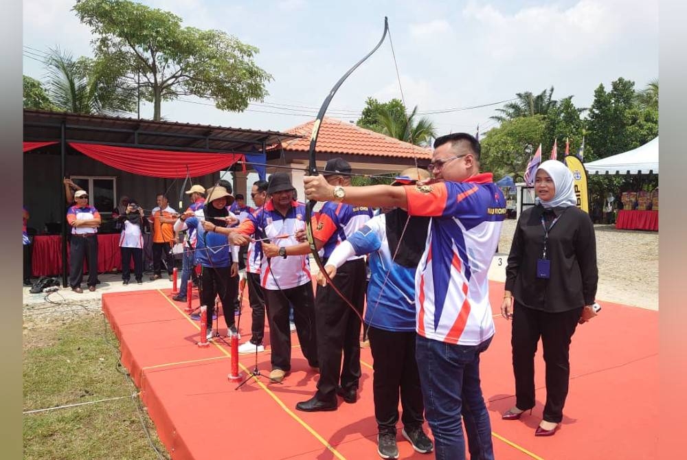 Mohd Hairi (kanan) cuba memanah dalam Kejohanan Memanah Antarabangsa Johor di Taman Mutiara Rini, Johor Bahru, pada Ahad