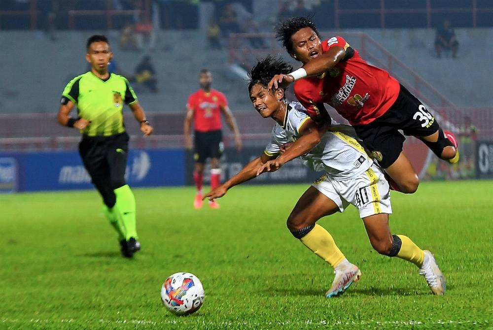 Pemain Negeri Sembilan, Mohd Zamri Pin Ramli (kanan) mengasak tonggak Perak, Muhammad Aiman Khairul Yusni pada perlawanan Liga Super di Stadium Tuanku Abdul Rahman, Paroi pada Ahad.