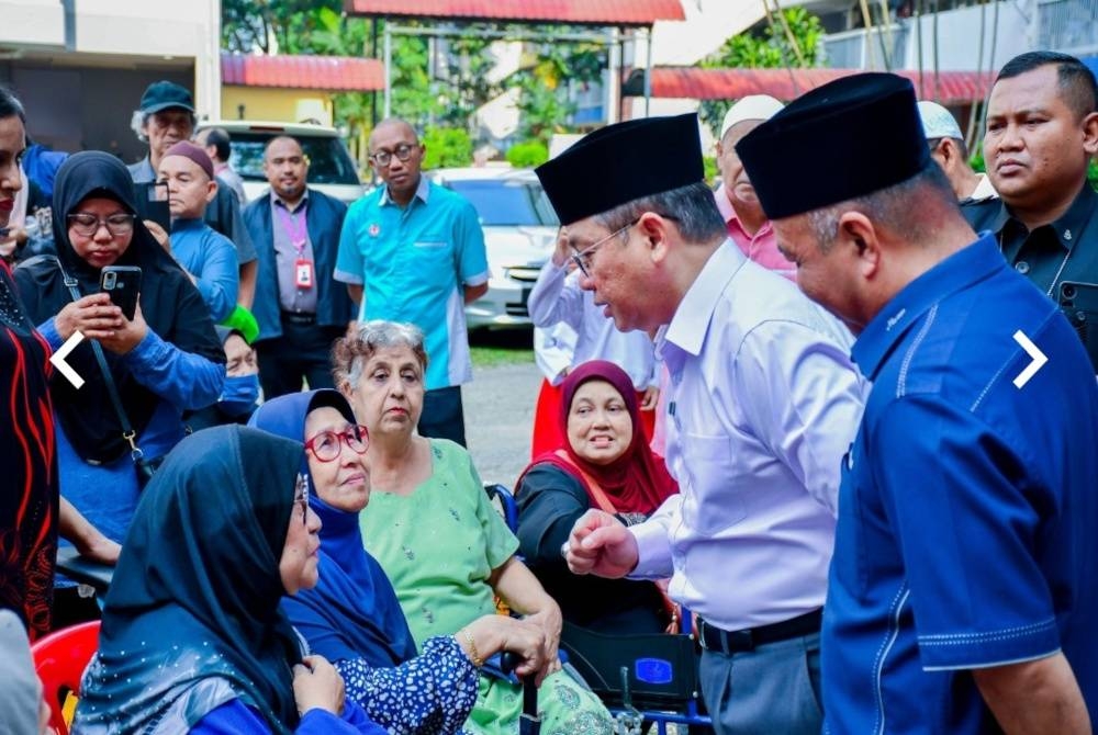 Mohd Na’im (dua dari kanan) beramah mesra bersama penerima pada Program Santunan Kasih Asnaf MAIWP di Perumahan Awam Sri Kota, Bandar Tun Razak di sini pada Isnin.