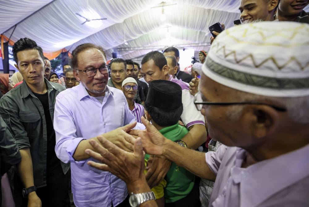 Anwar beramah mesra dengan sebahagian hadirin pada Karnival Segalanya Felda Wilayah Mempaga di Felda Chemomoi hari ini. Foto Bernama