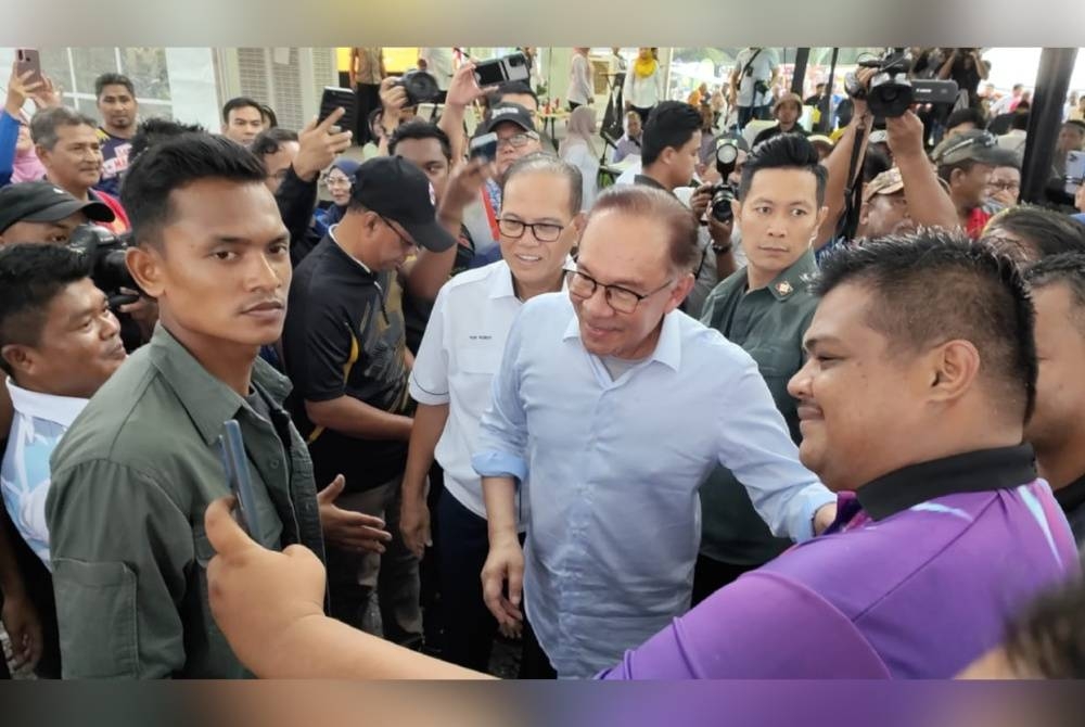 Anwar bertemu warga peneroka di Karnival Segalanya Felda di Dataran Niaga Felda Chemomoi di sini pada Isnin.