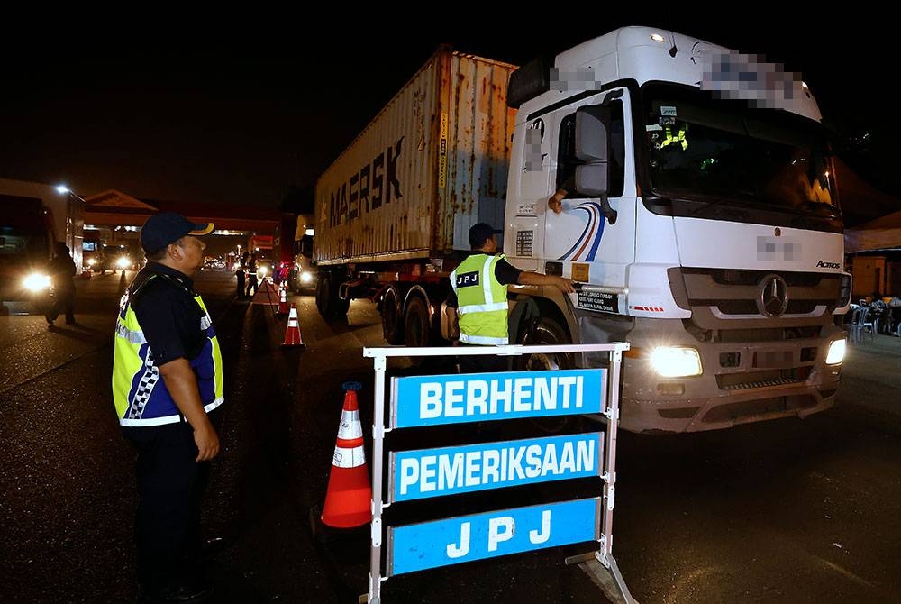 Anggota JPJ memeriksa kenderaan berat pada Majlis Pelancaran dan Pelaksanaan Operasi Kenderaan Komersial di Plaza Tol Kemuning Lebuh Raya KESAS hari ini. Foto Bernama