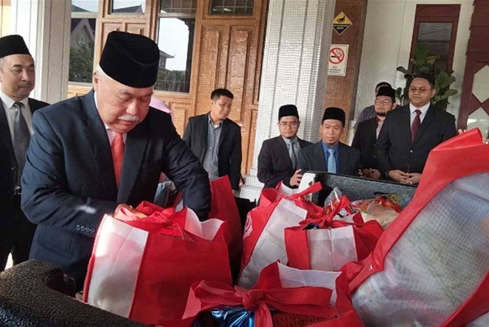 Mohamad Rizam (kiri) melihat bakul makanan yang dihantar ke Pos Bihai dan Belatim, Gua Musang.