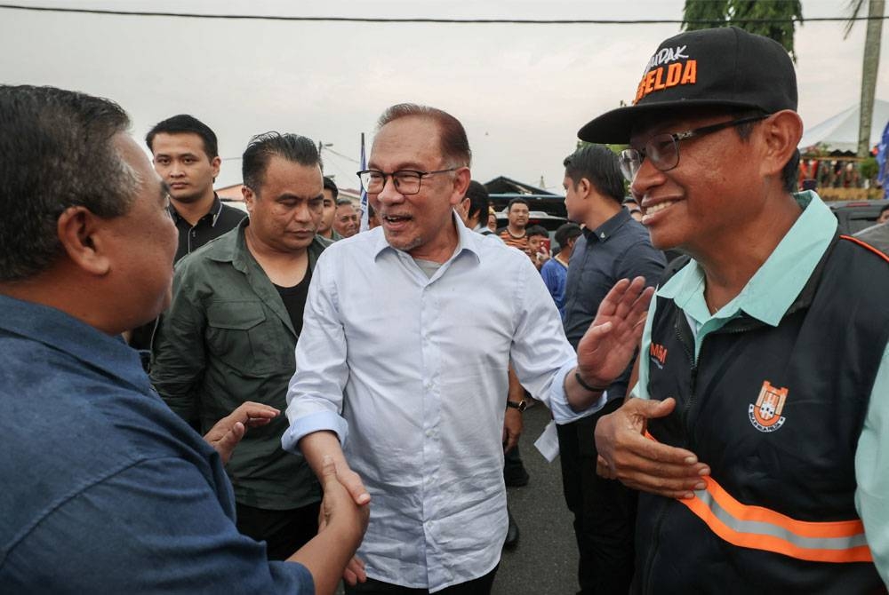 Anwar ketika tiba pada Karnival Segalanya Felda Wilayah Mempaga di Felda Chemomoi, Bentong pada Isnin. Turut kelihatan Pengerusi Felda, Datuk Seri Ahmad Shabery Cheek (kanan). - Foto Bernama