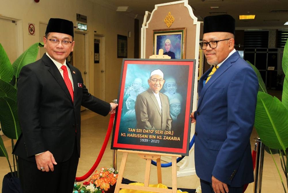 Mohd Na’im (kiri) bersama Dr Wan Sobri melihat potret Almarhum Harussani yang dipamerkan di Perpustakaan Raja Ashman Shah sempena Seminar Antarabangsa Pemikiran Mufti Harussani pada Selasa.