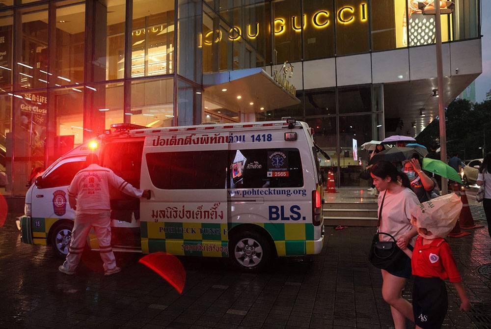 Sebuah ambulans kelihatan di luar Siam Paragon Mall di Bangkok berikutan insiden tembakan di pusat beli-belah itu. - Foto AFP