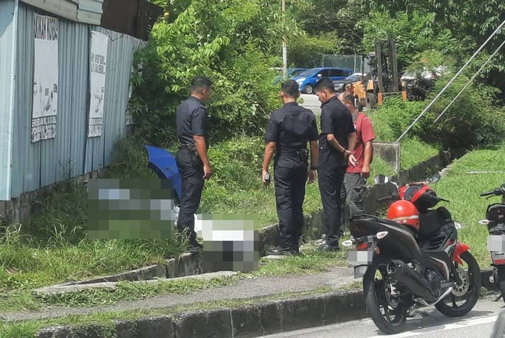 Anggota polis memeriksa mayat yang ditemui di tepi longkang, laluan menghala susur keluar MRR2 pada Selasa.