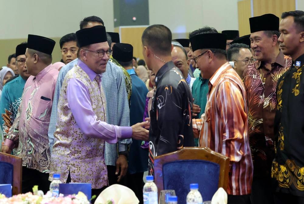 Anwar (dua dari kiri) bersalaman dengan orang ramai ketika tiba di Pusat Konvensyen Antarabangsa Sabah Kota Kinabalu untuk merasmikan Konvensyen Pengurusan Hal Ehwal Islam sempena Ijtimak Perdana Agensi Agama Seluruh Malaysia (IJAM 2023) pada Rabu. - Foto Bernama