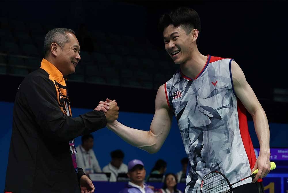 Perseorangan lelaki utama negara Lee Zii Jia bersama jurulatihnya Wong Tat Meng selepas menundukkan juara dunia Kunlavut Vitidsan dari Thailand di pusingan ketiga acara badminton Sukan Asia Hangzhou 2022 di Gimnasium Binjiang pada Rabu. - Foto Bernama.