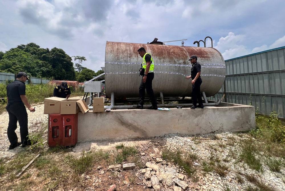 Penguat kuasa KPDN Temerloh memeriksa tangki berisi bekalan minyak diesel yang ditemui di stor penyimpanan haram di Kampung Bukit Tingkat, Jalan Lubuk Kawah di sini pada Rabu.