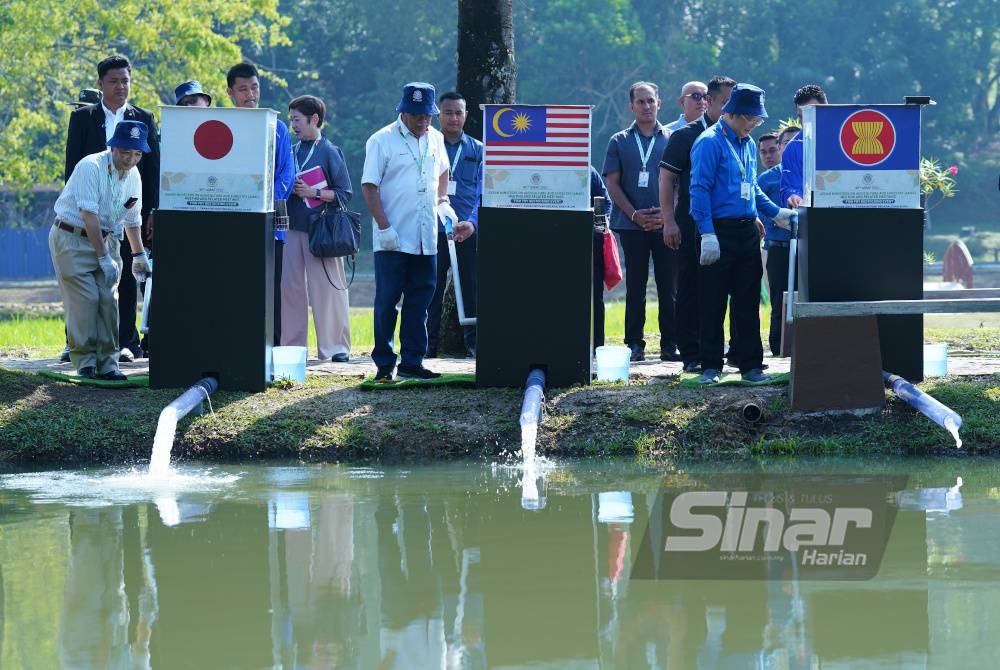 Mohamad bersama delegasi melepaskan 10,000 ekor anak ikan lampam sungai dan ikan terbul di Kolam Nusantara yang dikendalikan oleh pihak DOF. - Foto Sinar Harian MOHD HALIM ABDUL WAHID