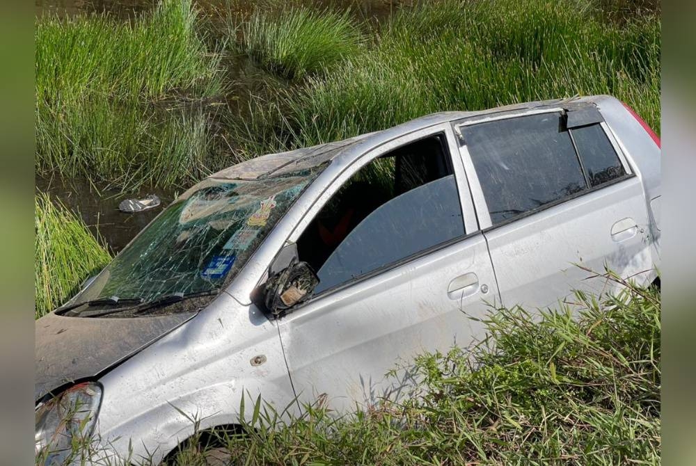 Kereta Perodua Viva dinaiki dua suspek dipercayai penagih dadah yang cuba melarikan diri daripada sekatan polis terbabas dalam parit di Parit 1 Ban ARBI 15, di sini pada Khamis.